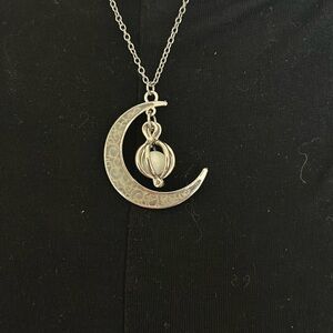 Half moon silver necklace with hanging pearl.